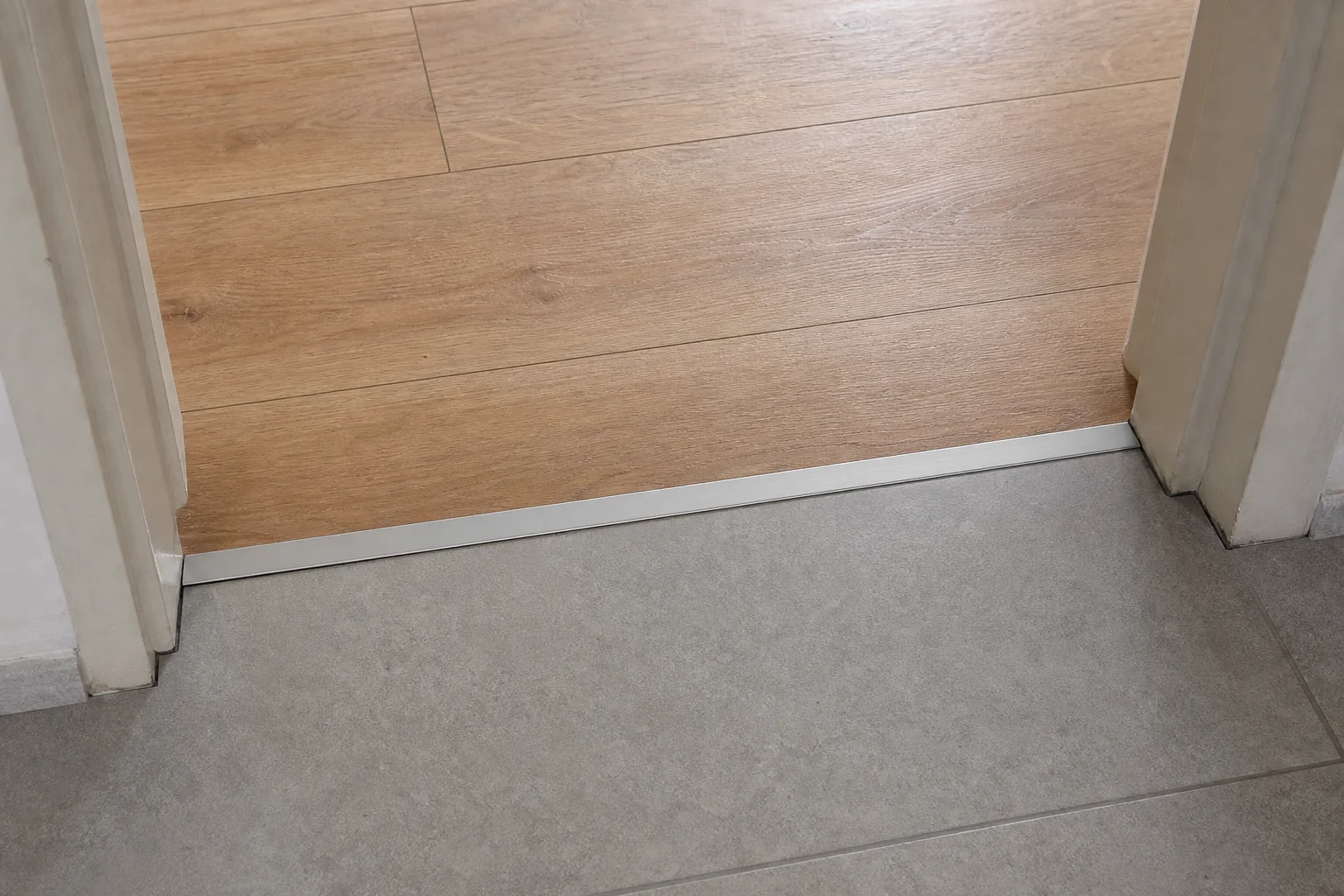 Detalle del encuentro entre un piso de madera y un solado cerámico resuelto con perfil de transición